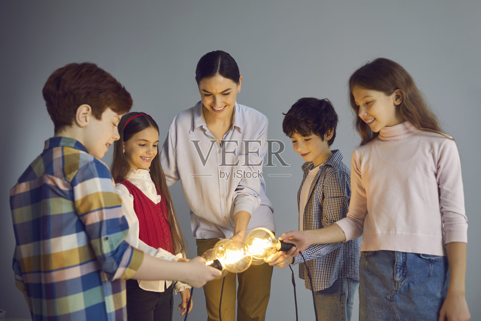 团队的快乐创意儿童和教师持有和加入明亮的想法灯泡照片摄影图片