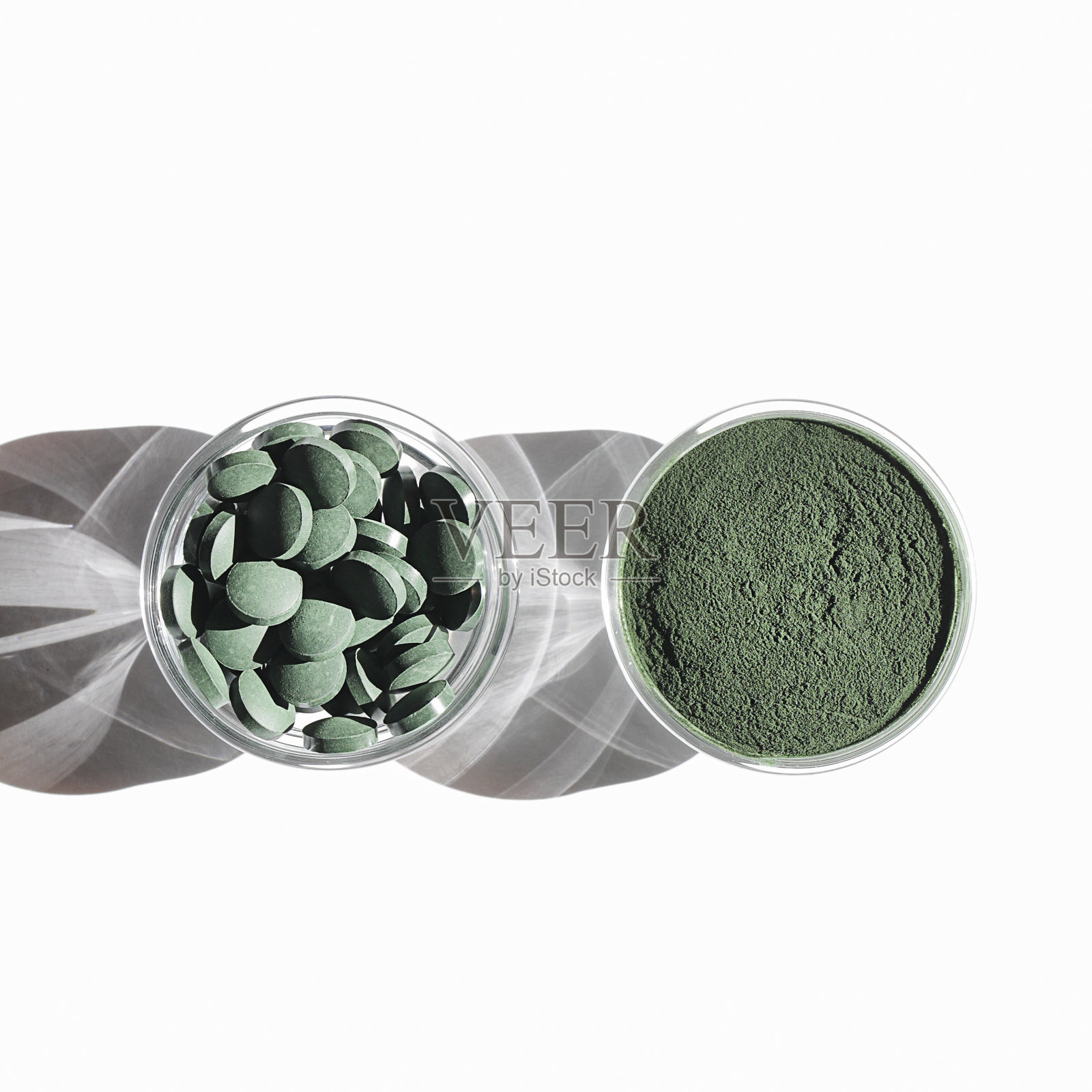 天然添加剂和超级食品。白色背景上的绿色螺旋藻粉和药丸。健康的生活方式的概念。有机食品广场照片摄影图片