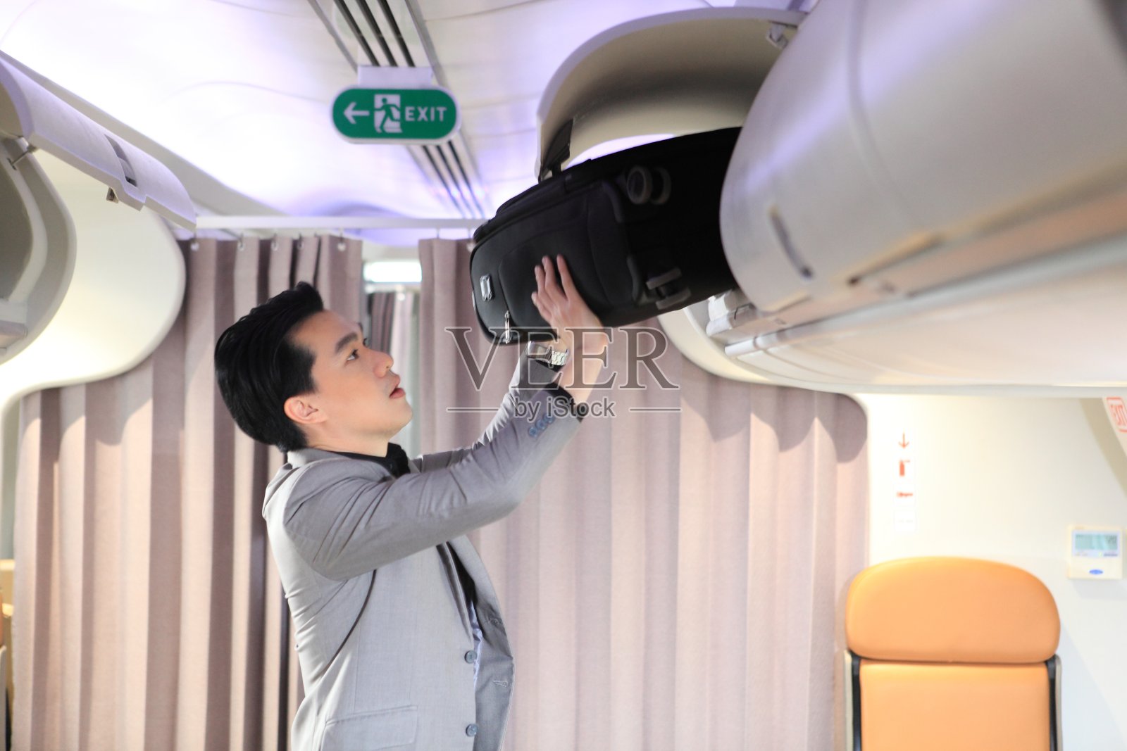 旅客在飞机上将包保存在机舱内照片摄影图片