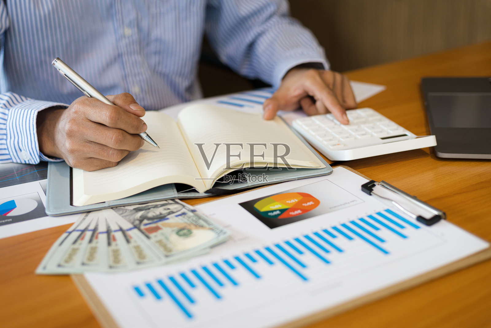 商人用计算器做计算,写笔记。会计概念与个人财务规划照片摄影图片