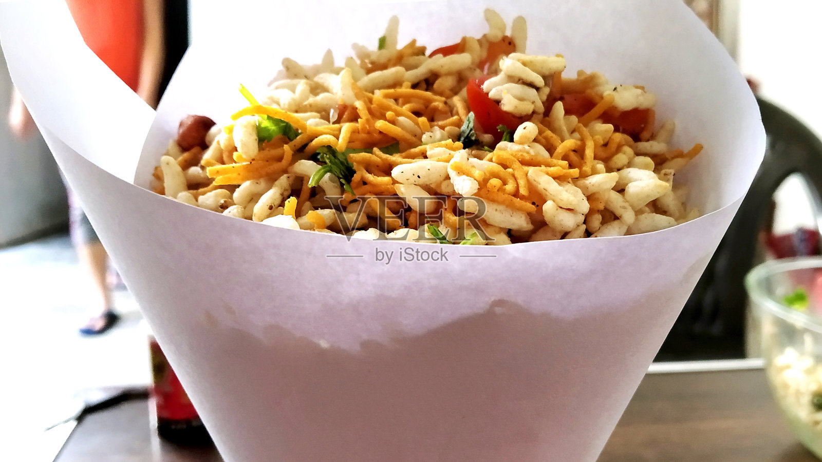 Bhel poori,一种装在锥形纸容器里的印度路边小吃照片摄影图片