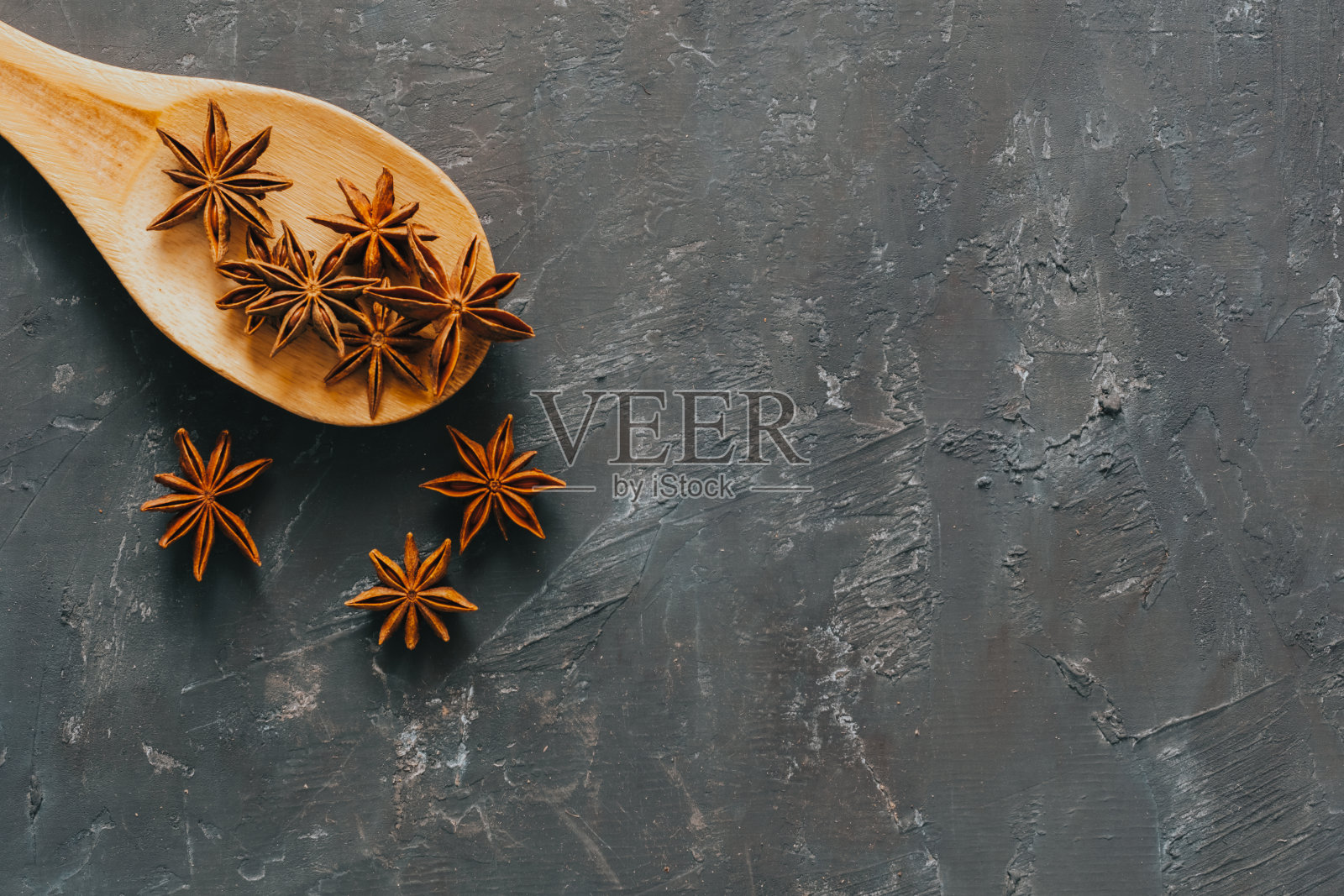 八角茴香在木勺黑色背景照片摄影图片