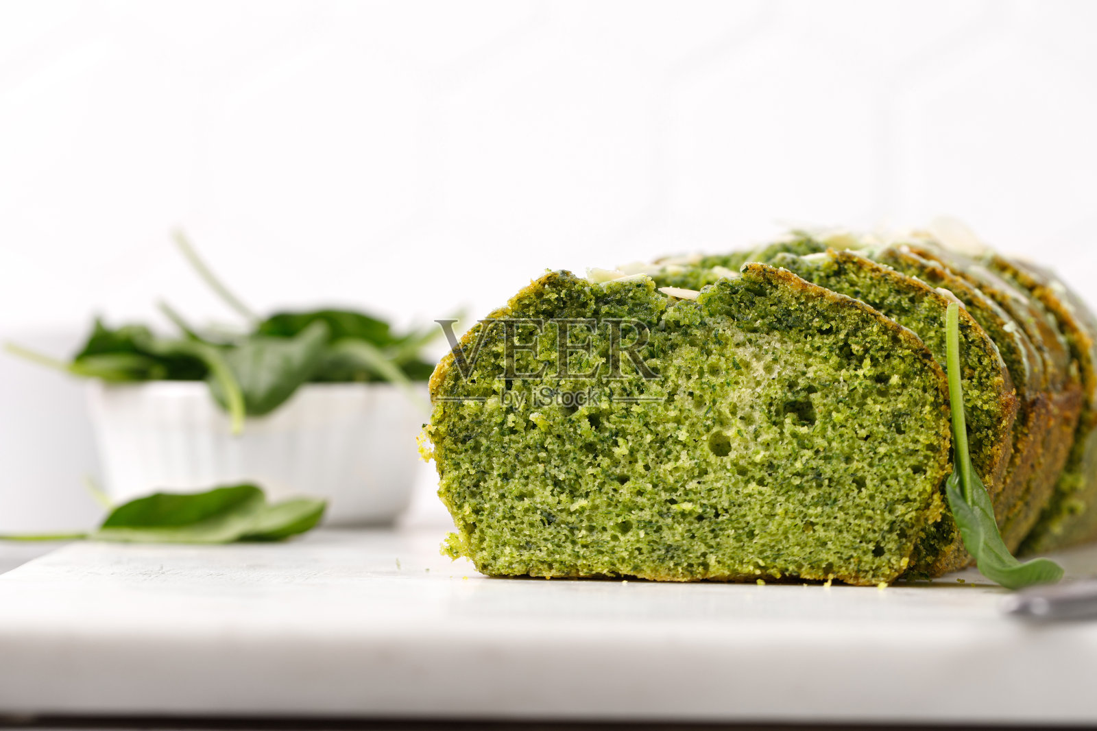 菠菜蛋糕,杏仁片切在大理石板上。海绵绿派。灰色背景。绿色蛋糕质地照片摄影图片