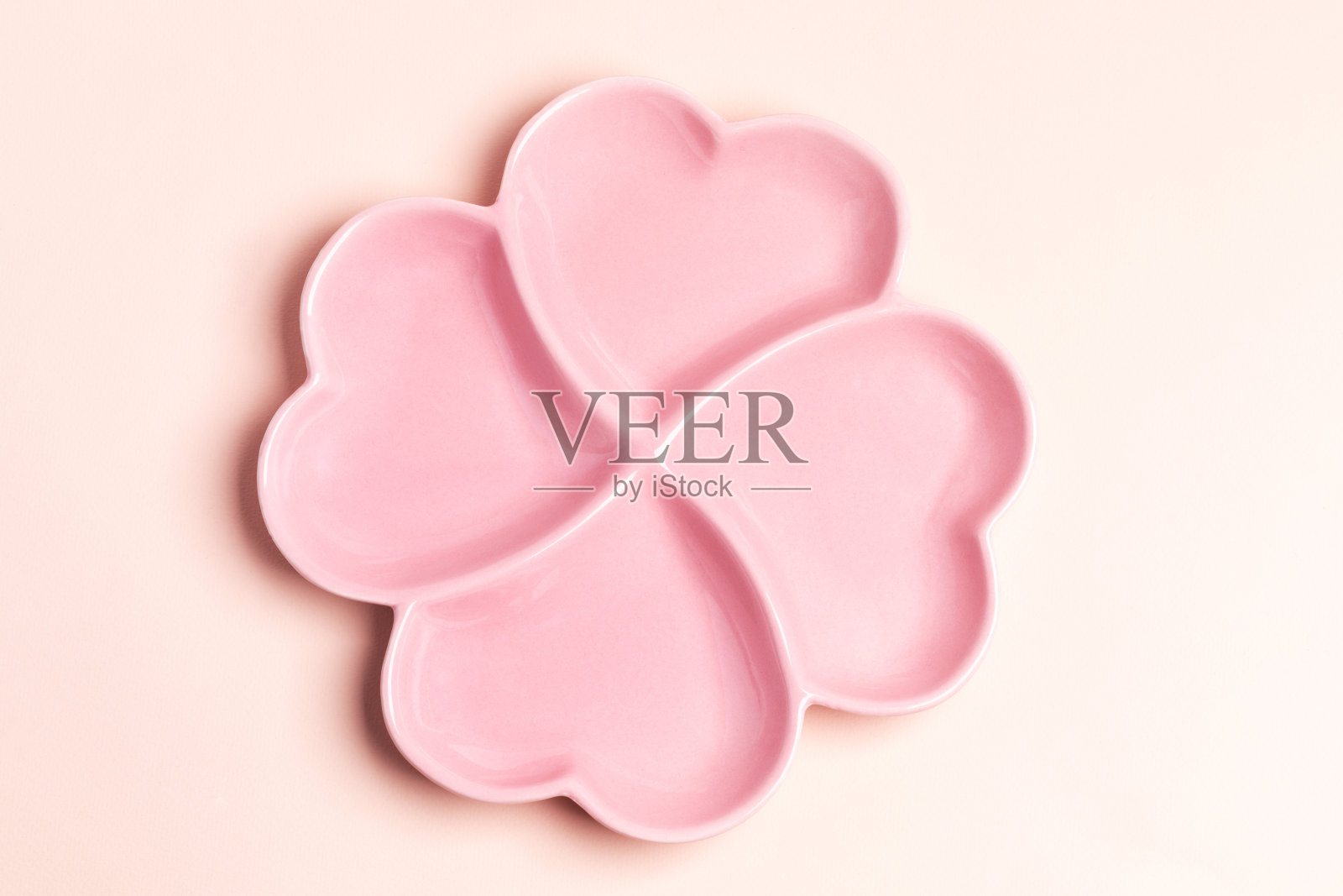 空粉红色盘子形式的四个心在粉彩背景。从以上观点。照片摄影图片