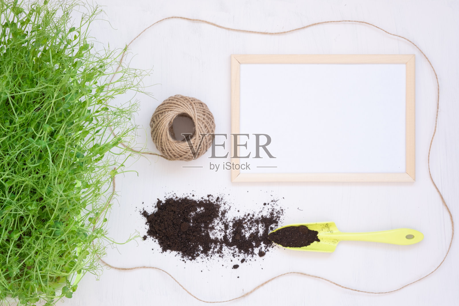 春天的概念在花园里工作。幼苗和其他植物。从以上观点。带有文本空间的框架。园艺工具,一把泥土和植物。美丽的背景,明信片照片摄影图片
