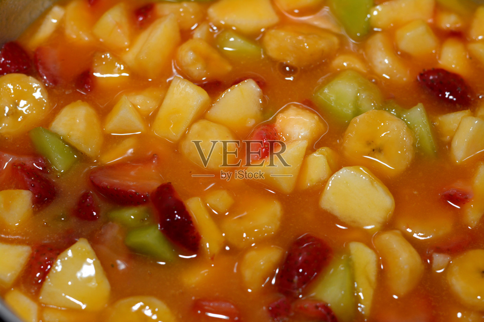 香蕉草莓哈密瓜苹果芒果橙汁水果沙拉特写照片摄影图片