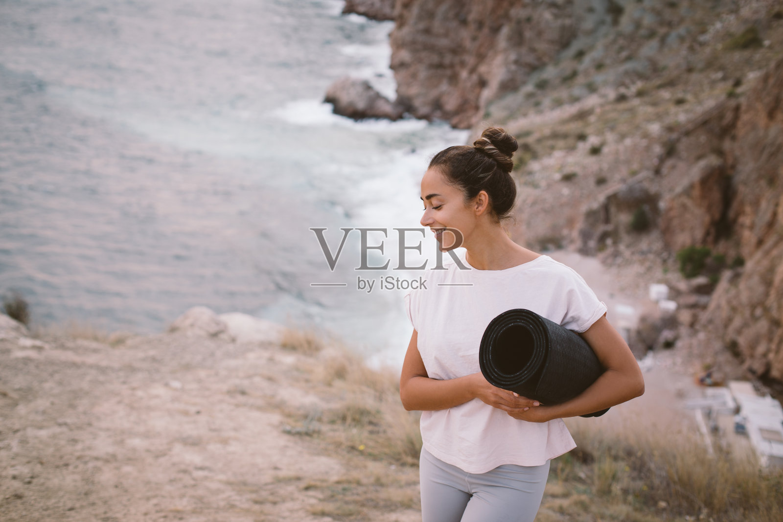 年轻女子在美丽的海景山上做瑜伽练习。照片摄影图片