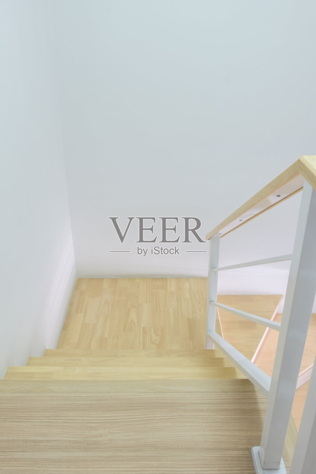 城市住宅内带白色金属扶手的现代弧形木制楼梯照片摄影图片