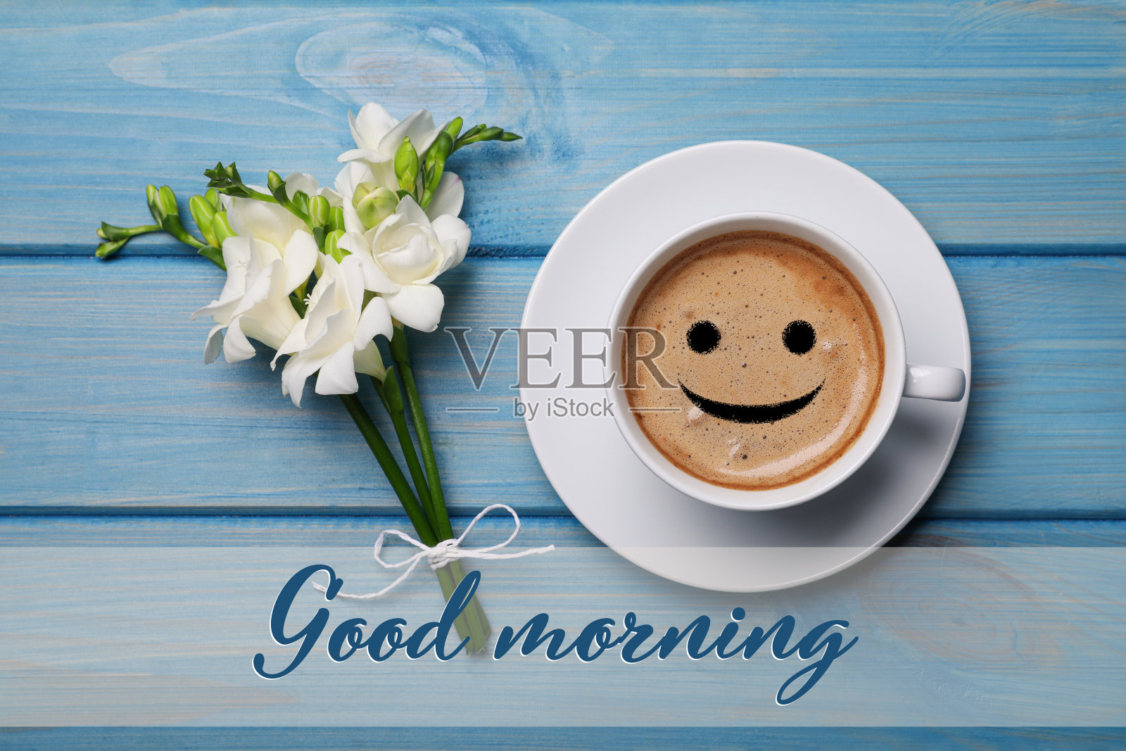 香喷喷的咖啡和鲜花放在浅蓝色的木桌上,平铺着。早上好照片摄影图片