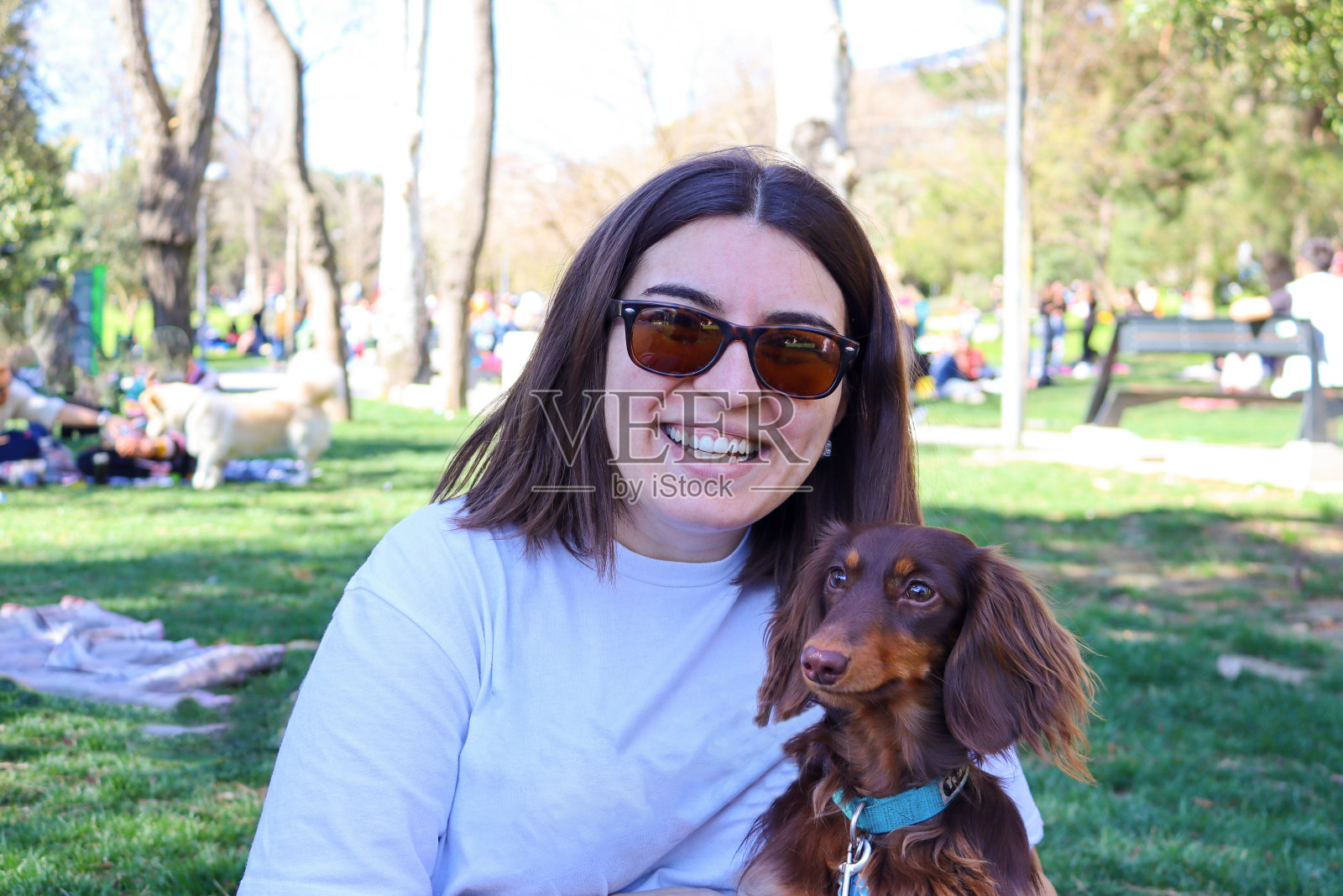 这位女士正带着她的腊肠犬看着镜头照片摄影图片