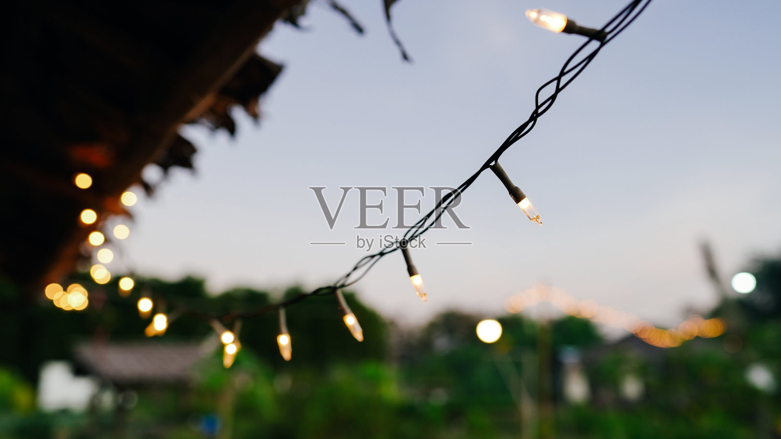 照亮黄昏的花园灯光。照片摄影图片