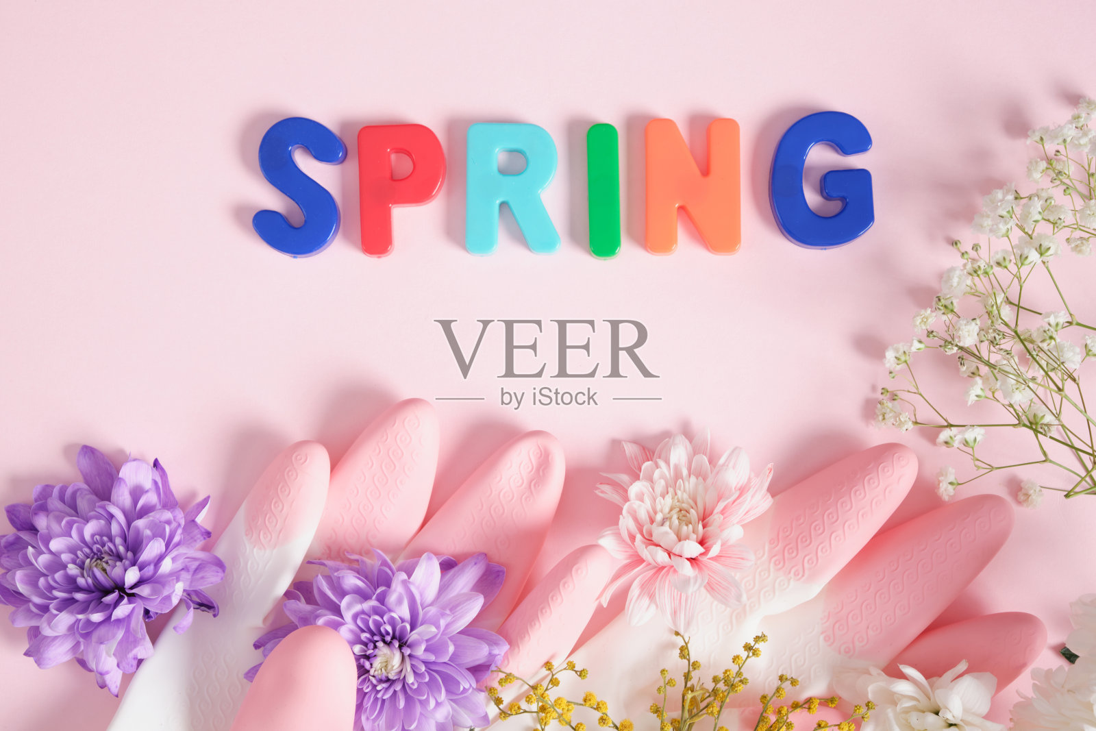 刻字春天,鲜花和橡胶手套,春天清洁概念,粉红色的背景照片摄影图片