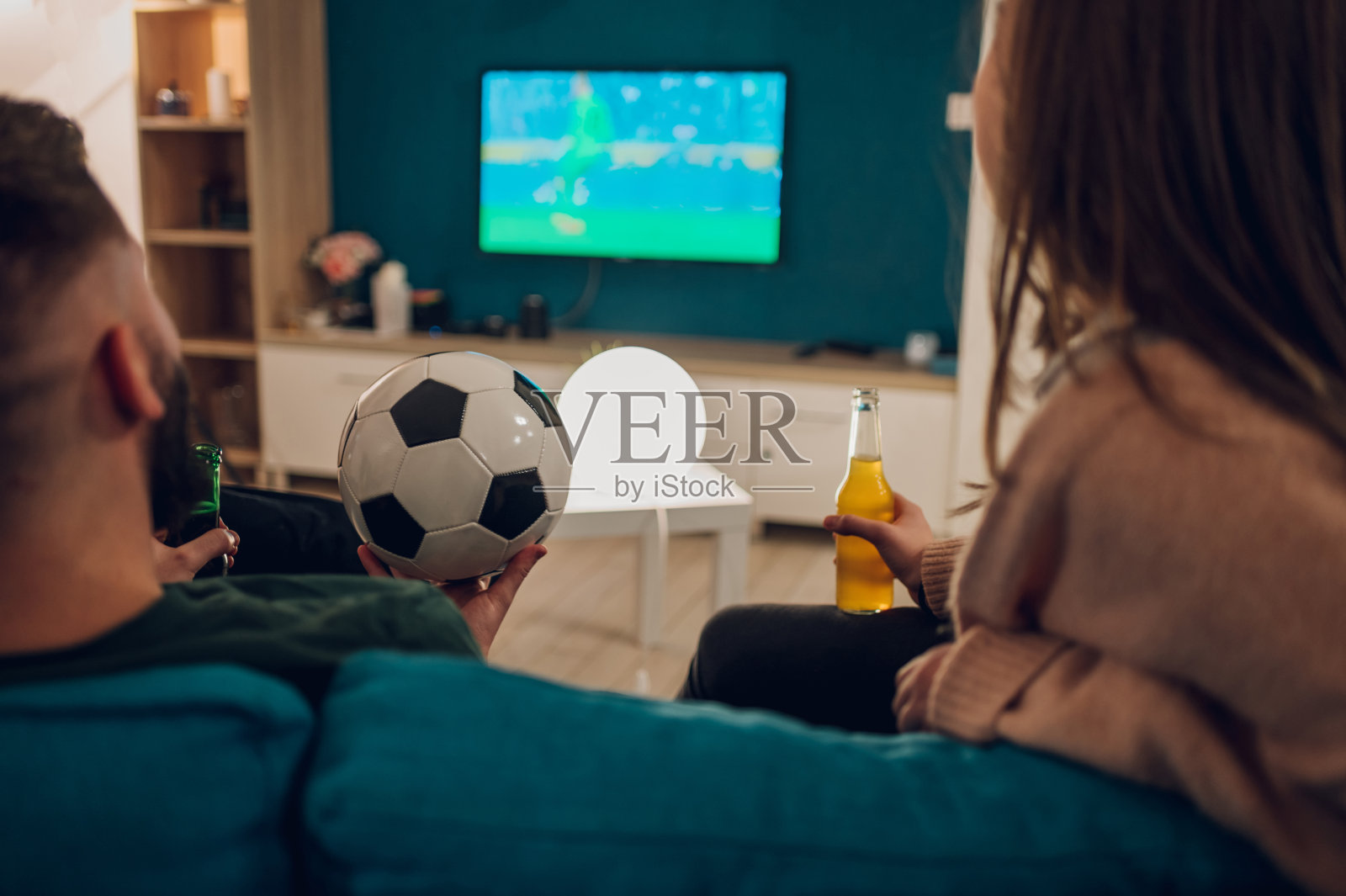 朋友们在家里观看足球比赛并欢呼照片摄影图片