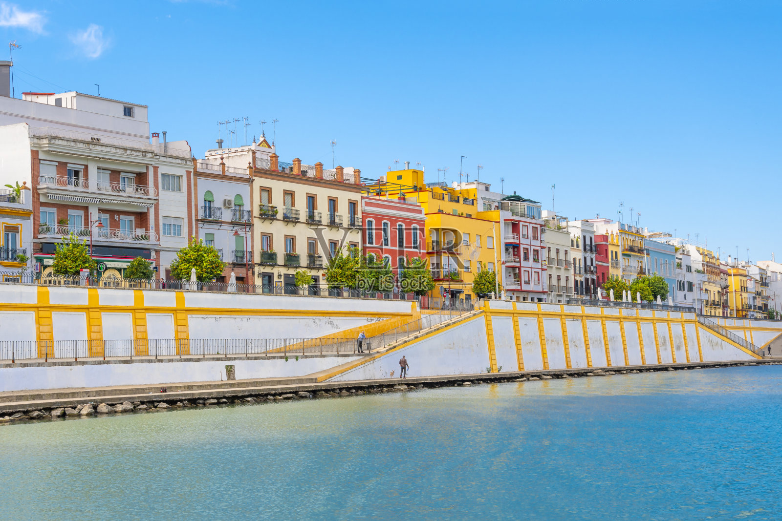 在西班牙历史悠久的安达卢西亚城市塞维利亚,瓜达尔基维尔河边的特里亚纳区充满活力的色彩。照片摄影图片