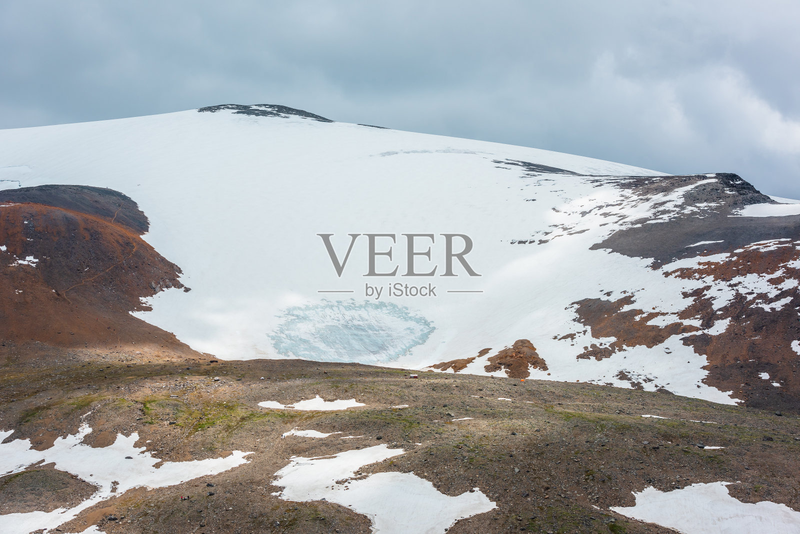 在多云的天空下,巨大的雪山圆顶在阳光下的戏剧性风景高山景观。五彩缤纷的山景,阳光照耀下的高雪山,在变幻的天气下,云雾缭绕。照片摄影图片