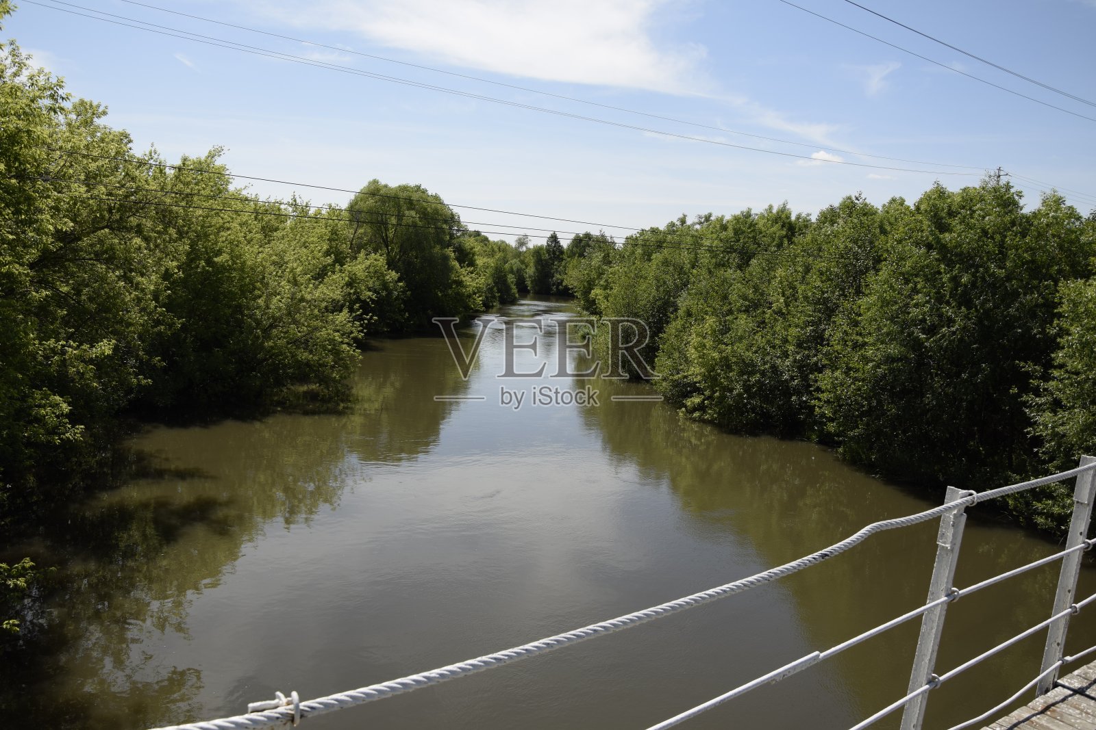 金属悬索桥穿过河流茂密的植被。俄罗斯乌里扬诺夫斯克。照片摄影图片