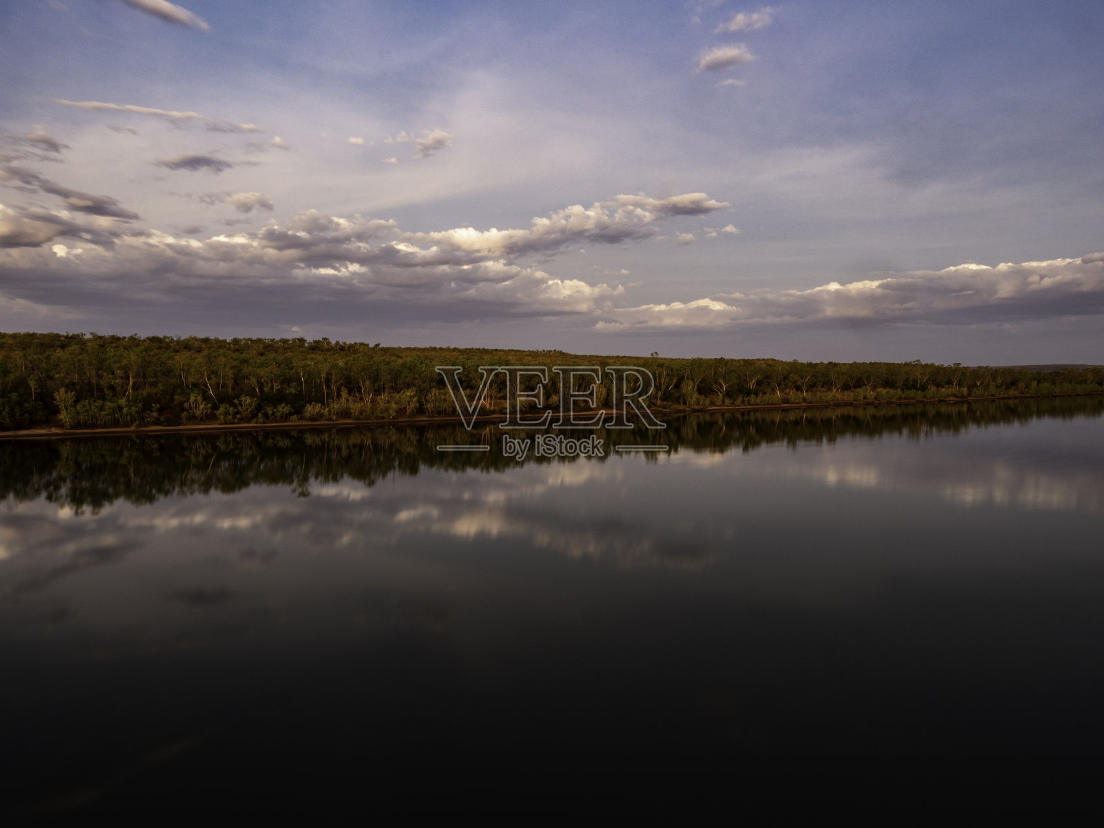 夕阳西下,静水映在河上照片摄影图片
