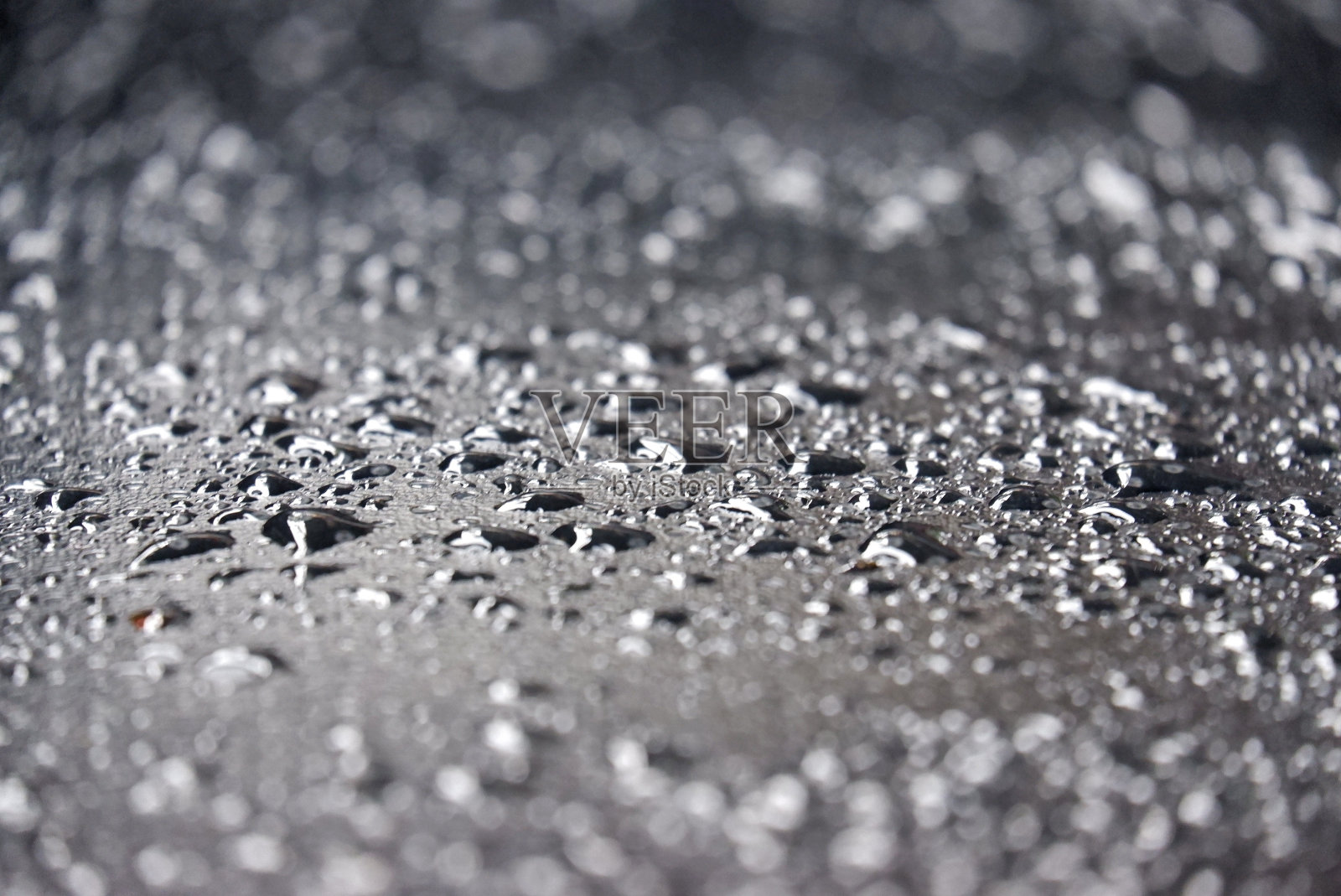 模糊许多水滴在黑色皮革与散景灯湿润皮肤模式照片摄影图片