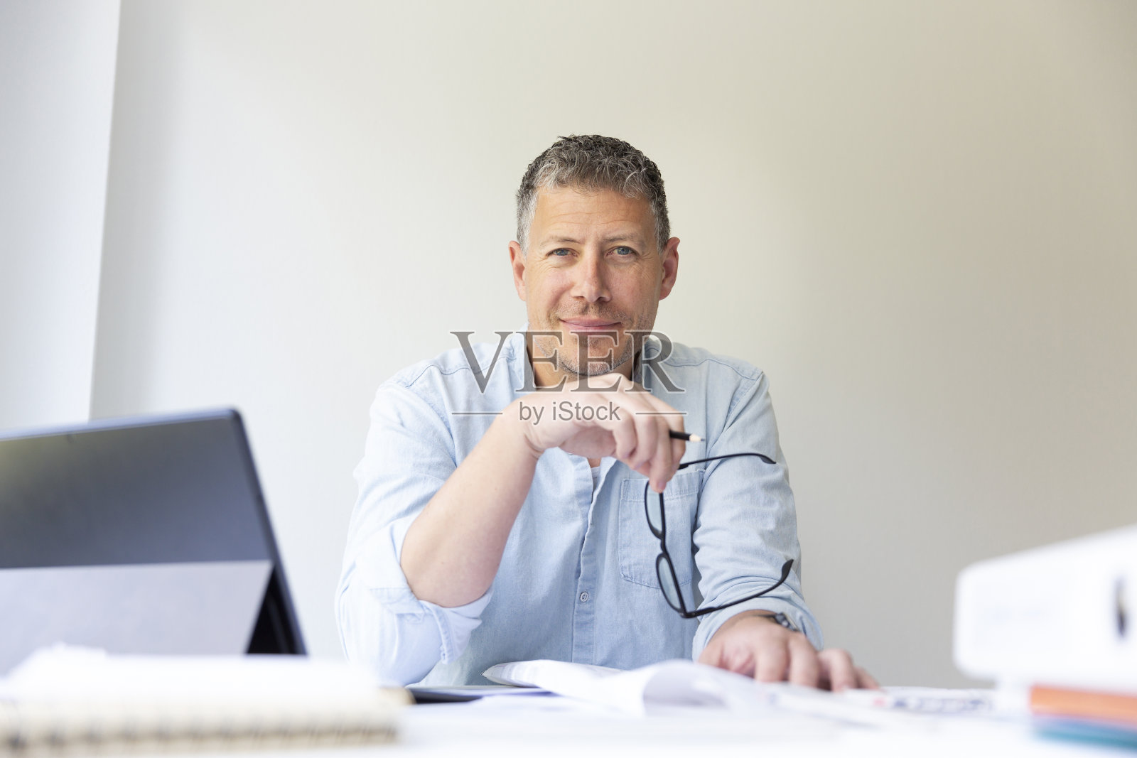 商业肖像建筑师坐在他的工作桌旁和计划照片摄影图片