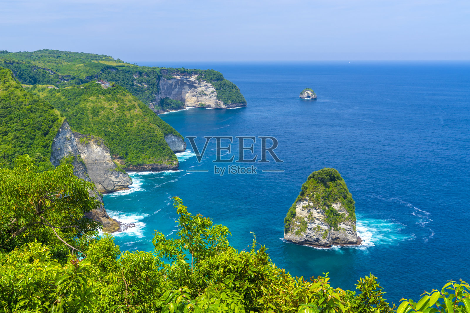 在努萨佩尼达岛的克林金海滩附近,帕琅悬崖位于美丽的蓝色水域之上。照片摄影图片