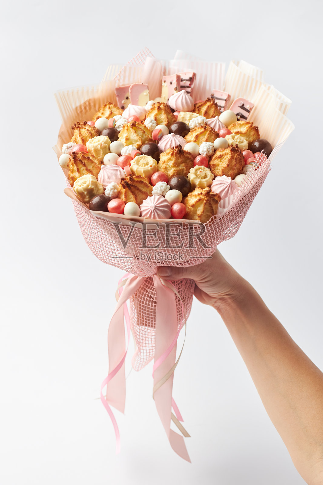 一名女性手里拿着一束有趣的甜饼干、棉花糖和巧克力照片摄影图片