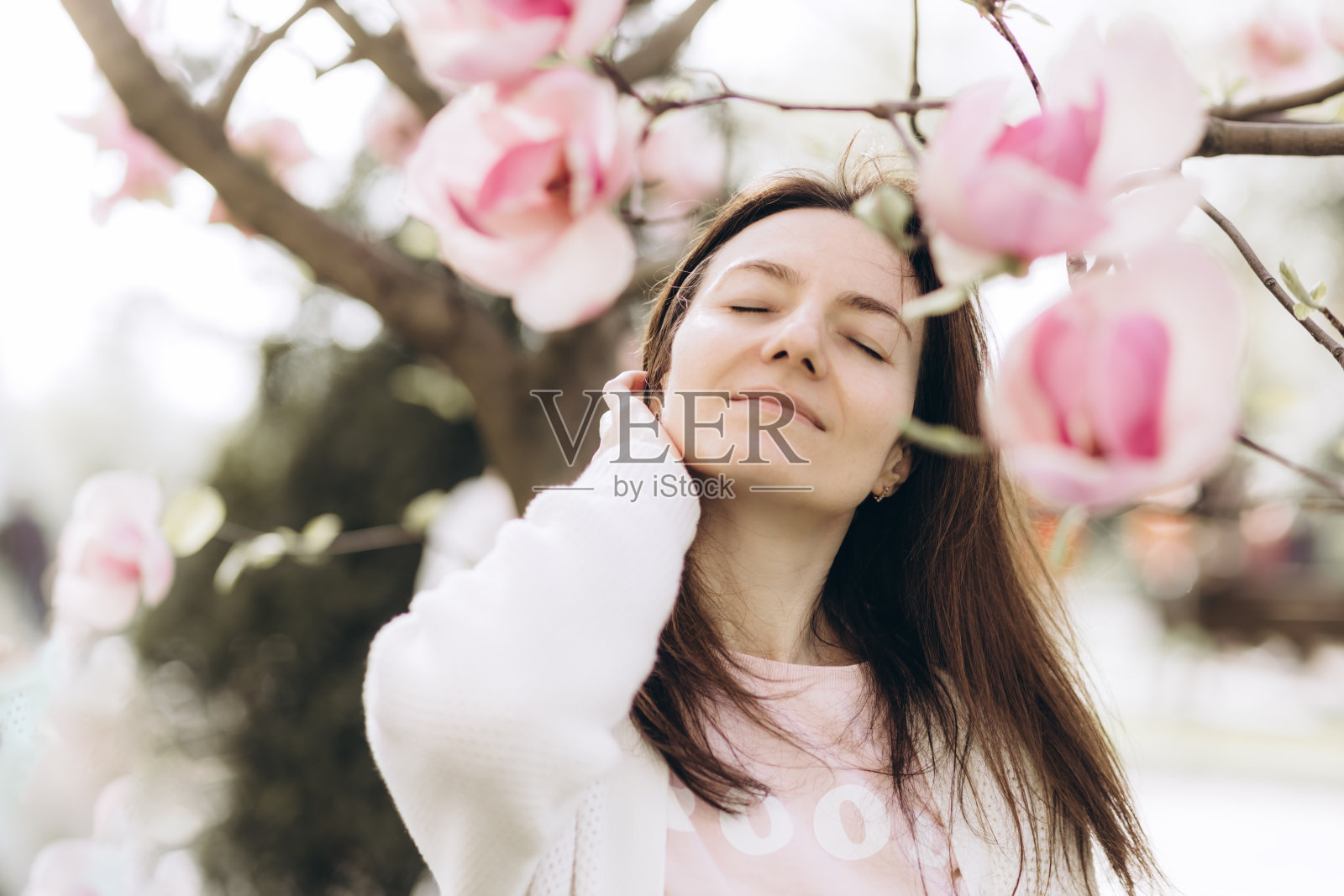 年轻女子和玉兰花。照片摄影图片