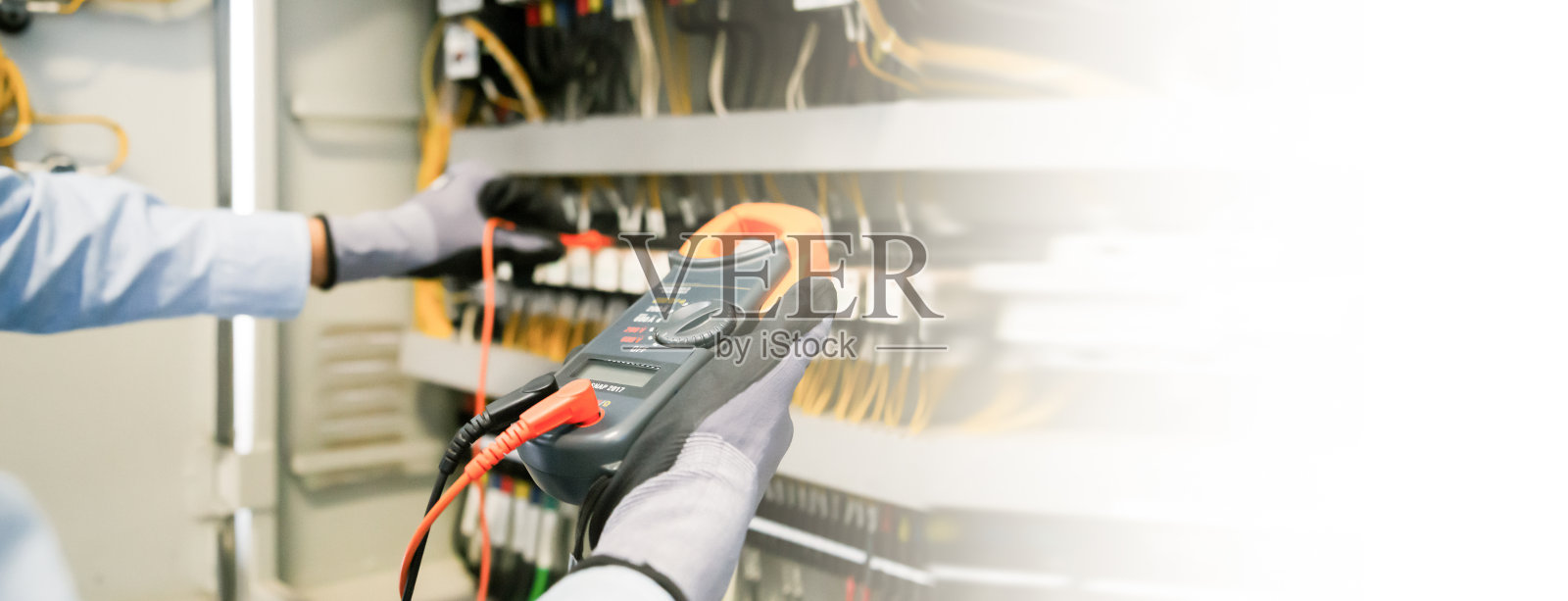 电气工程师测试保护继电器上的电气装置和接线,用万用表测量。照片摄影图片