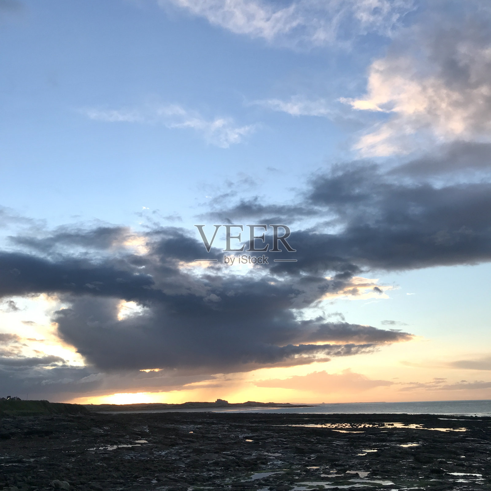 从英国英国诺森伯兰的Seahouses港看到班伯勒和法恩群岛的日落照片摄影图片