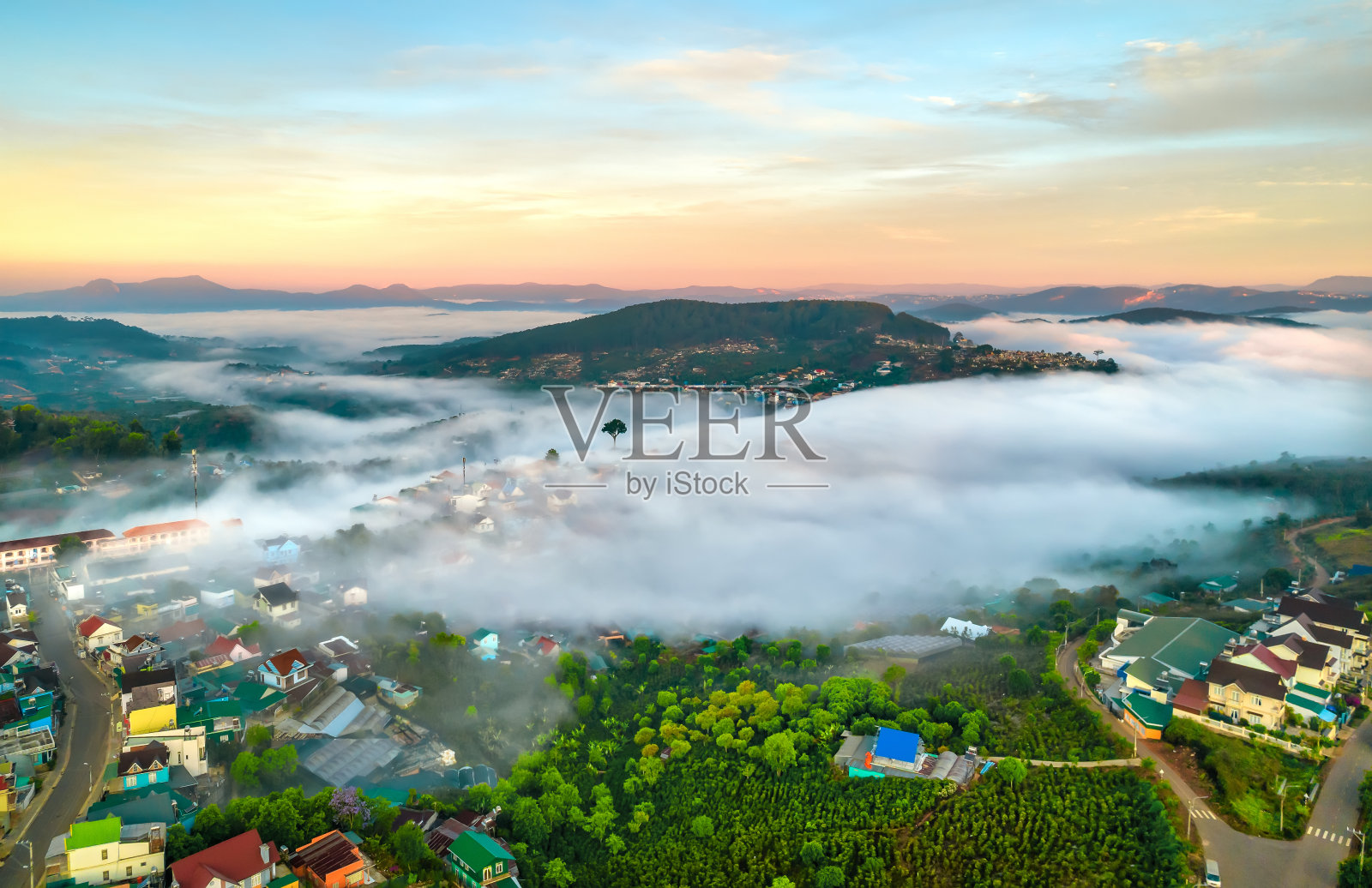 在日出的天空中鸟瞰小镇的薄雾照片摄影图片