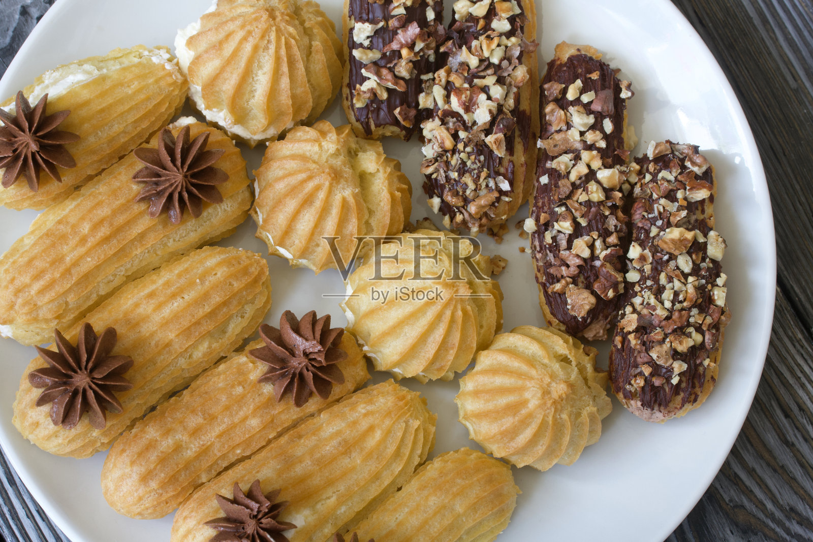 自制奶油泡芙。它们躺在盘子上。奶油蛋奶酥。特写镜头。照片摄影图片