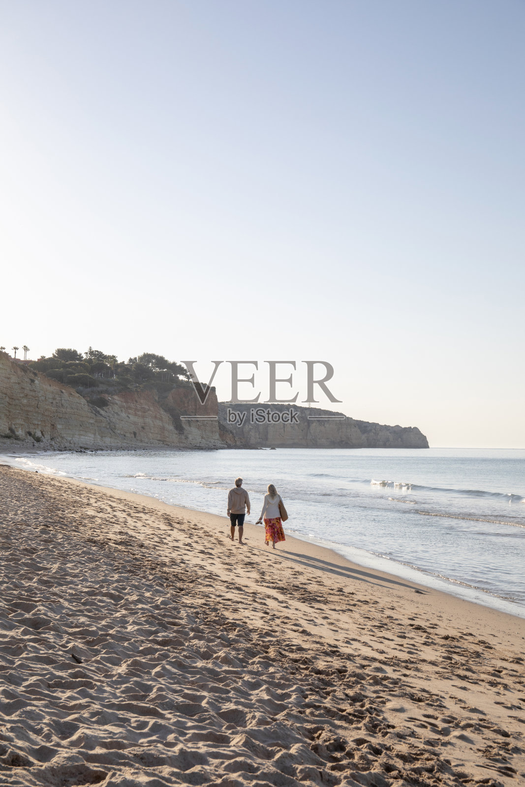 成熟的情侣赤脚走在沙滩上照片摄影图片