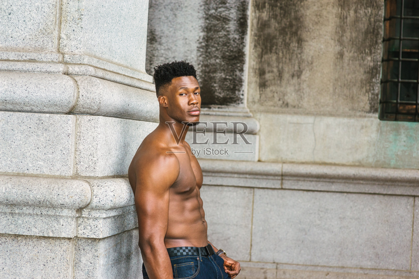 年轻的黑人男子站在纽约市的户外,望着别处照片摄影图片