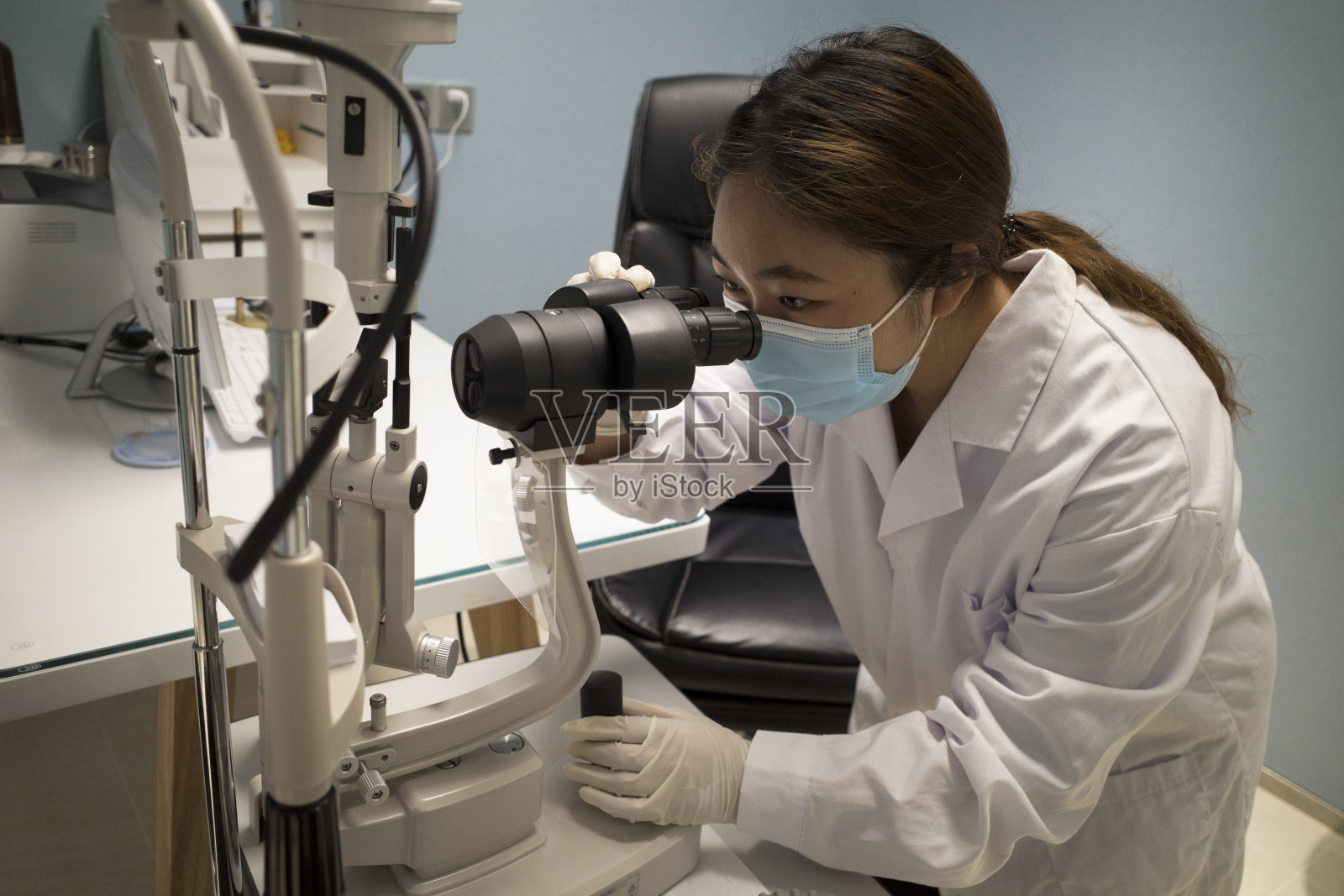 女医生在办公室使用眼科设备照片摄影图片