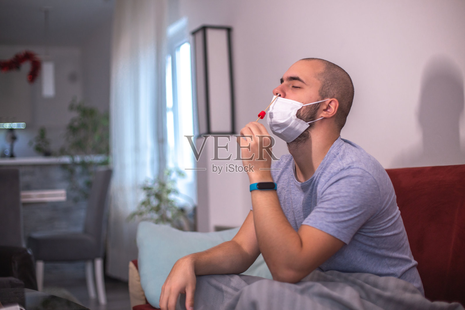 一名年轻男子在家中使用抗原试剂盒进行新冠病毒自我检测照片摄影图片