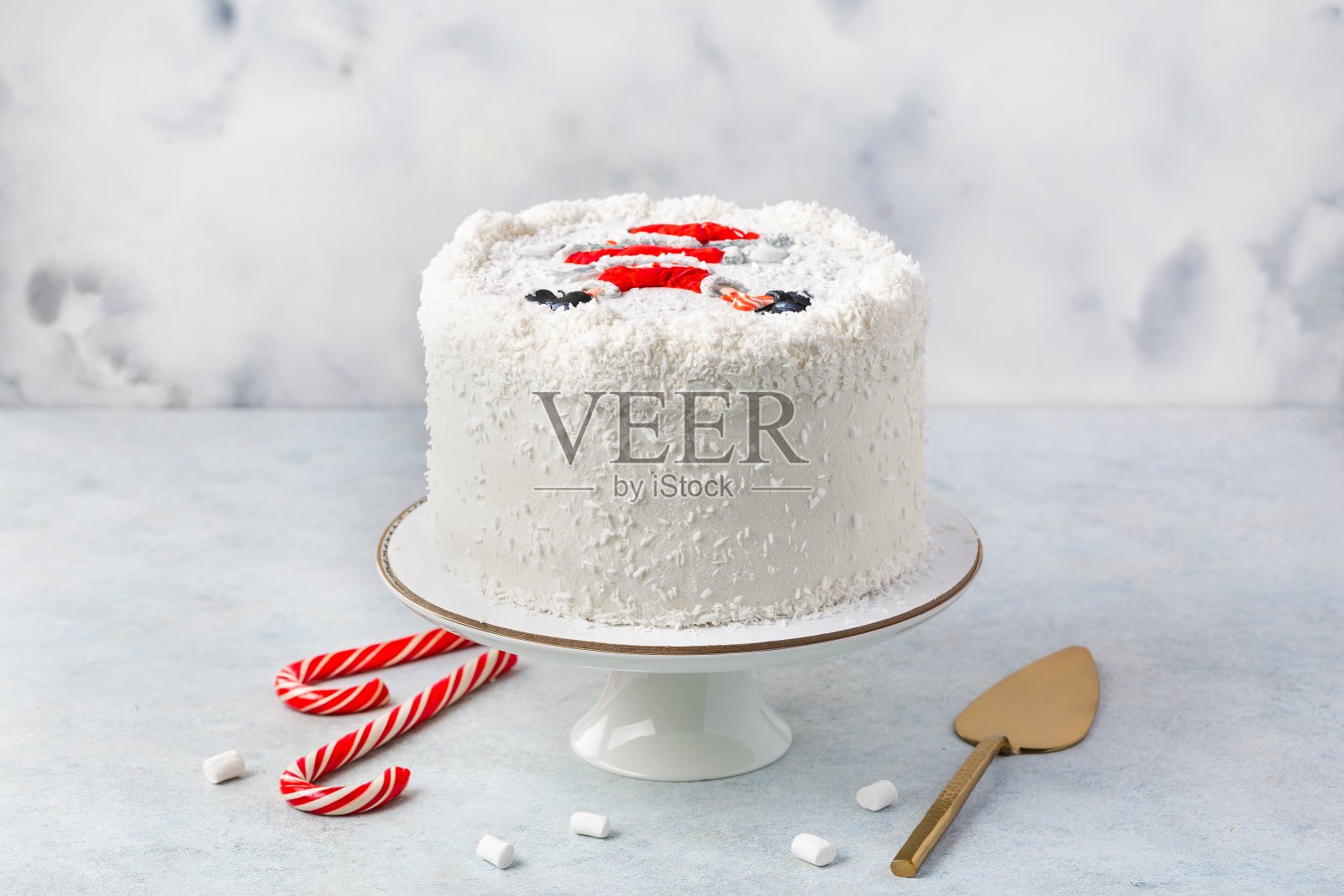 圣诞白色蛋糕装饰与圣诞老人的形象在白色背景与圣诞装饰或冬季假期糕点食品的概念。照片摄影图片