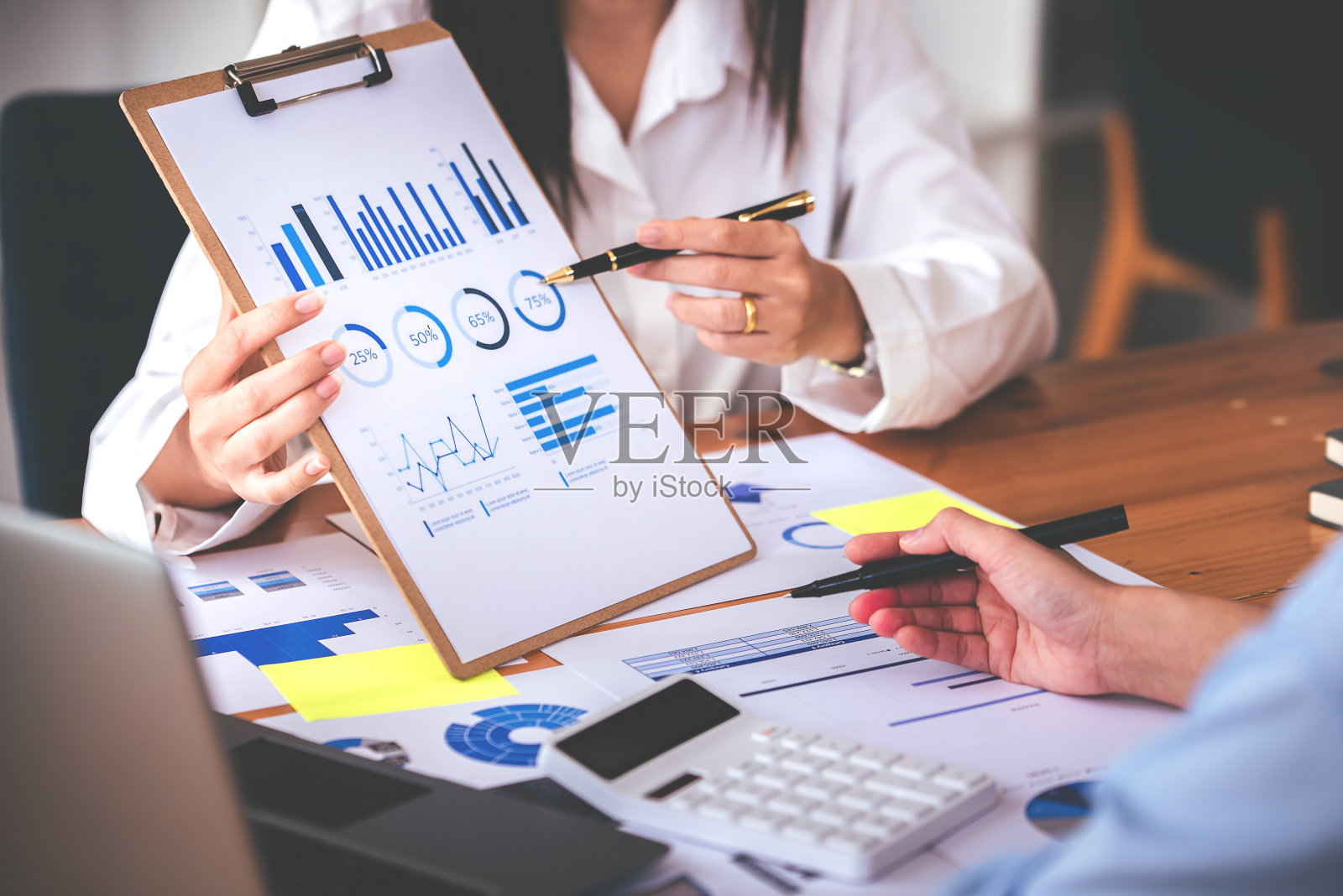 团队合作,将商业分析价格图表放在会议室的桌子上。照片摄影图片