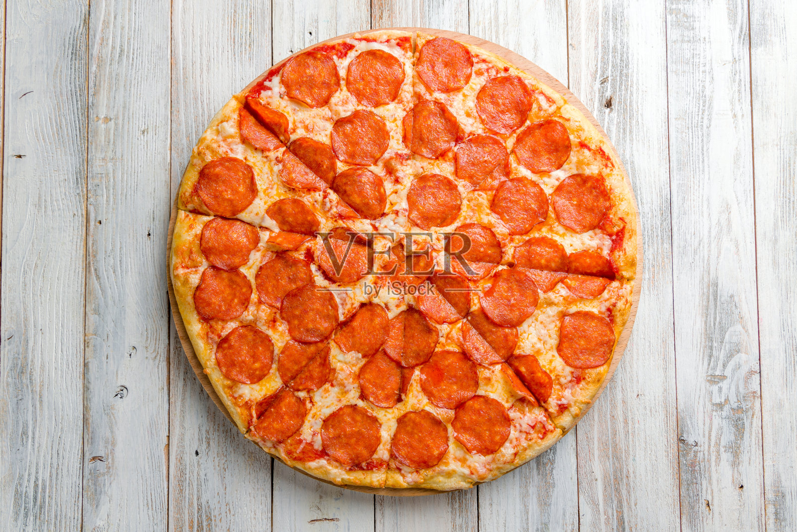 意大利辣香肠披萨在白色木制桌子上俯瞰视图照片摄影图片