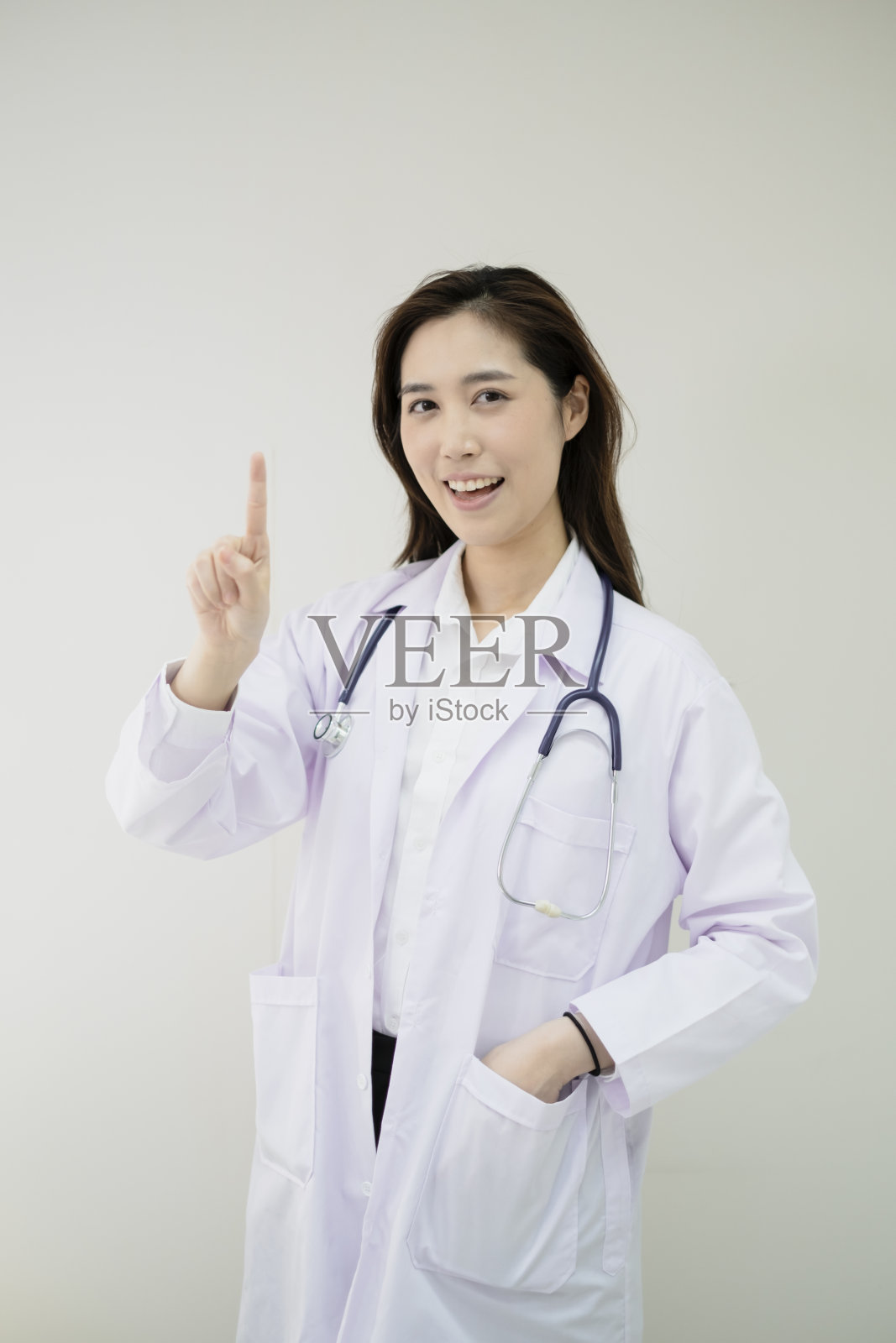 医生正站在她的办公室里。女医生拿着听诊器站在诊所里。照片摄影图片