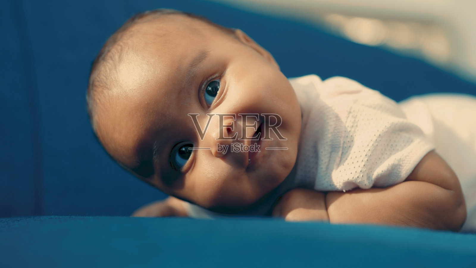 黑孩子躺在蓝色的沙发上照片摄影图片