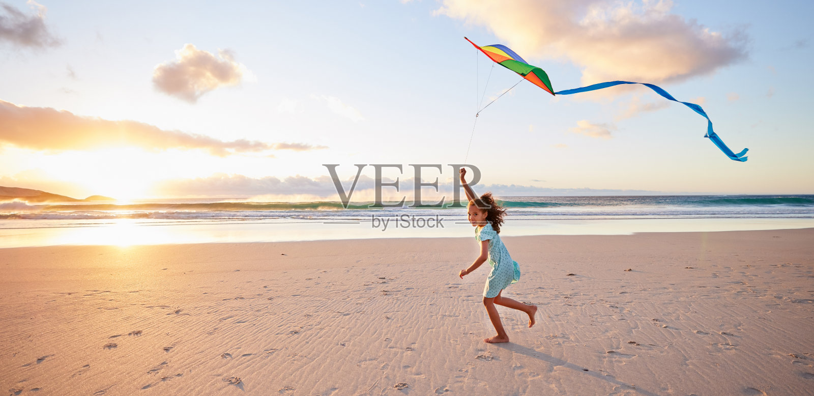 一个小女孩在沙滩上玩风筝的照片照片摄影图片