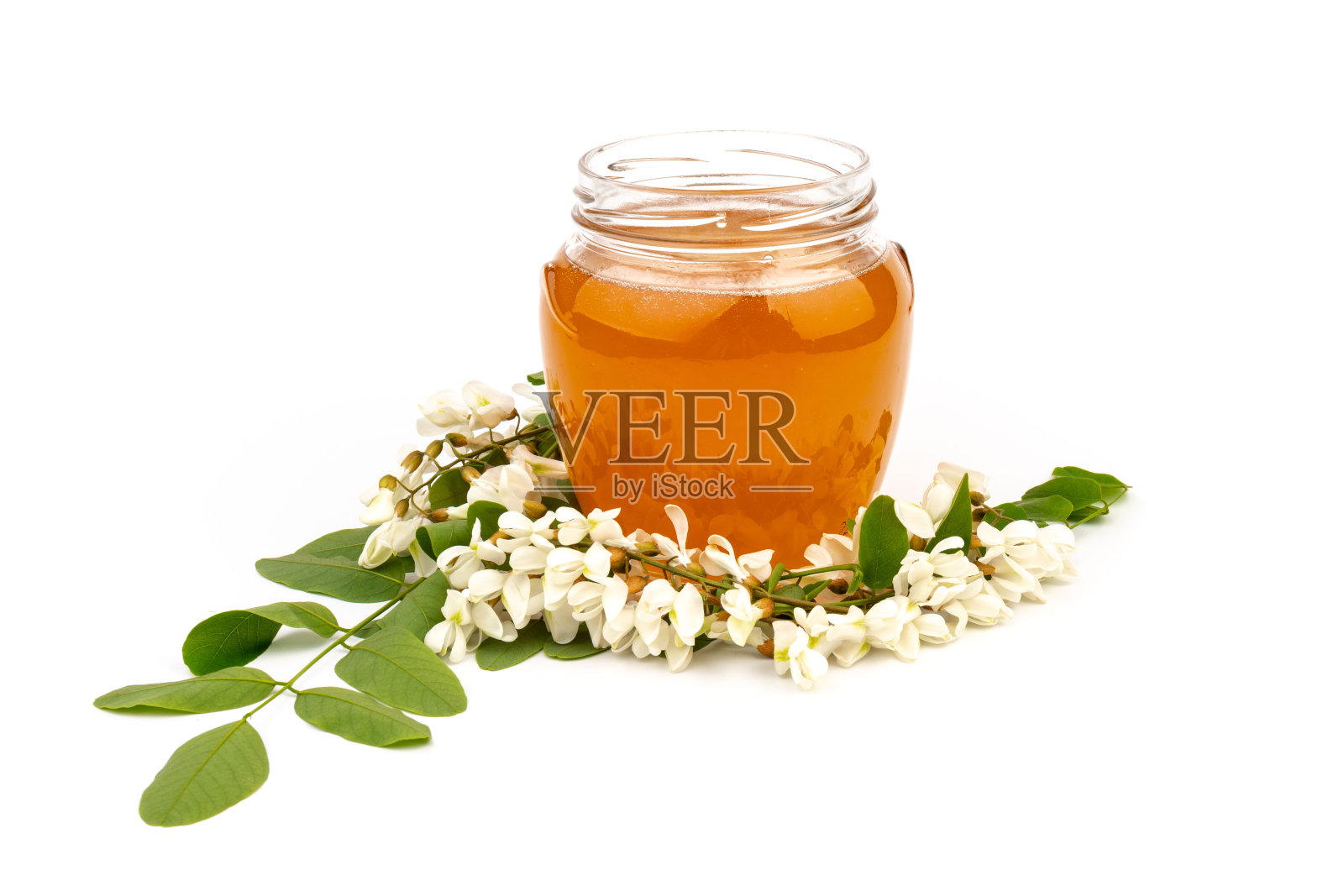 一罐蜂蜜与金合欢的花孤立在白色背景照片摄影图片