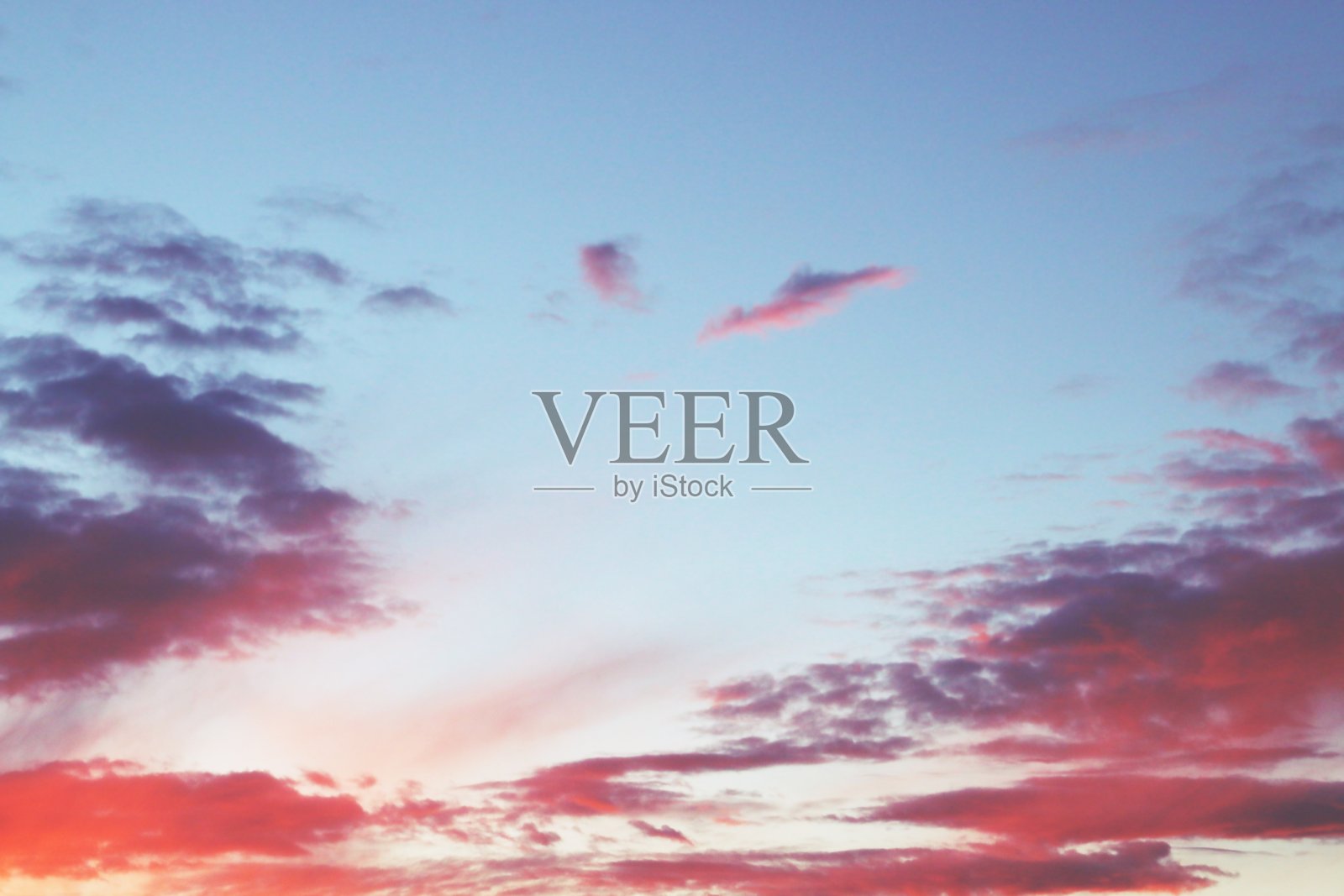 日落时,天空中有粉红色和橙色的云彩。照片摄影图片