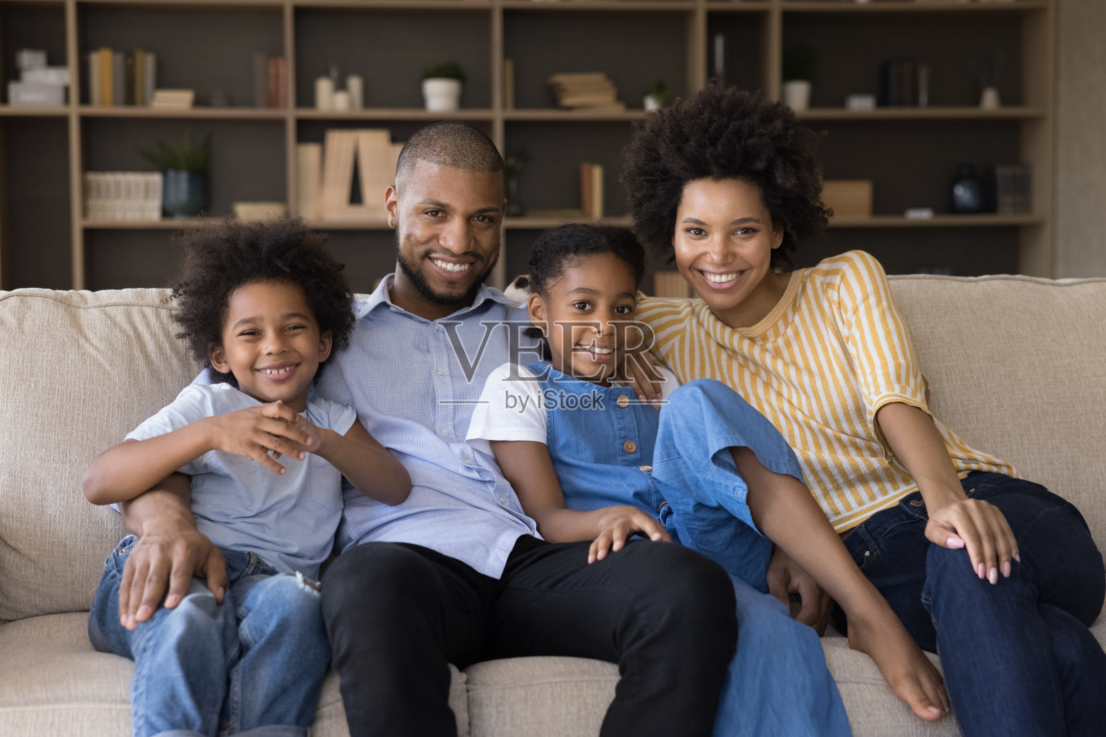 一对非洲夫妇和孩子坐在家里的沙发上照片摄影图片