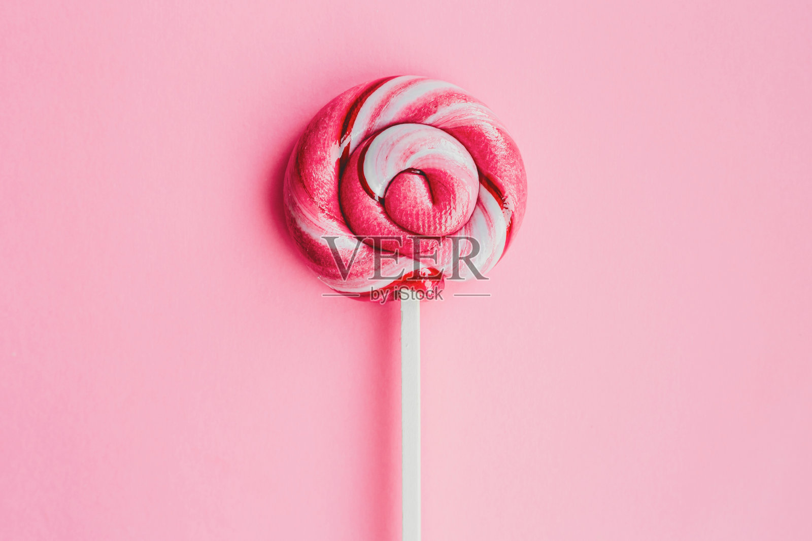 彩色的棒棒糖孤立在粉红色的背景。平的。副本的空间。最小的概念照片摄影图片