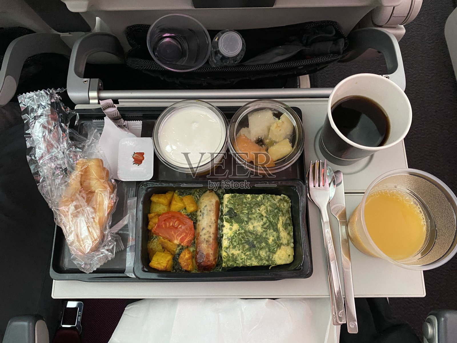 飞机上的煎蛋卷、香肠、土豆和饮料套餐照片摄影图片