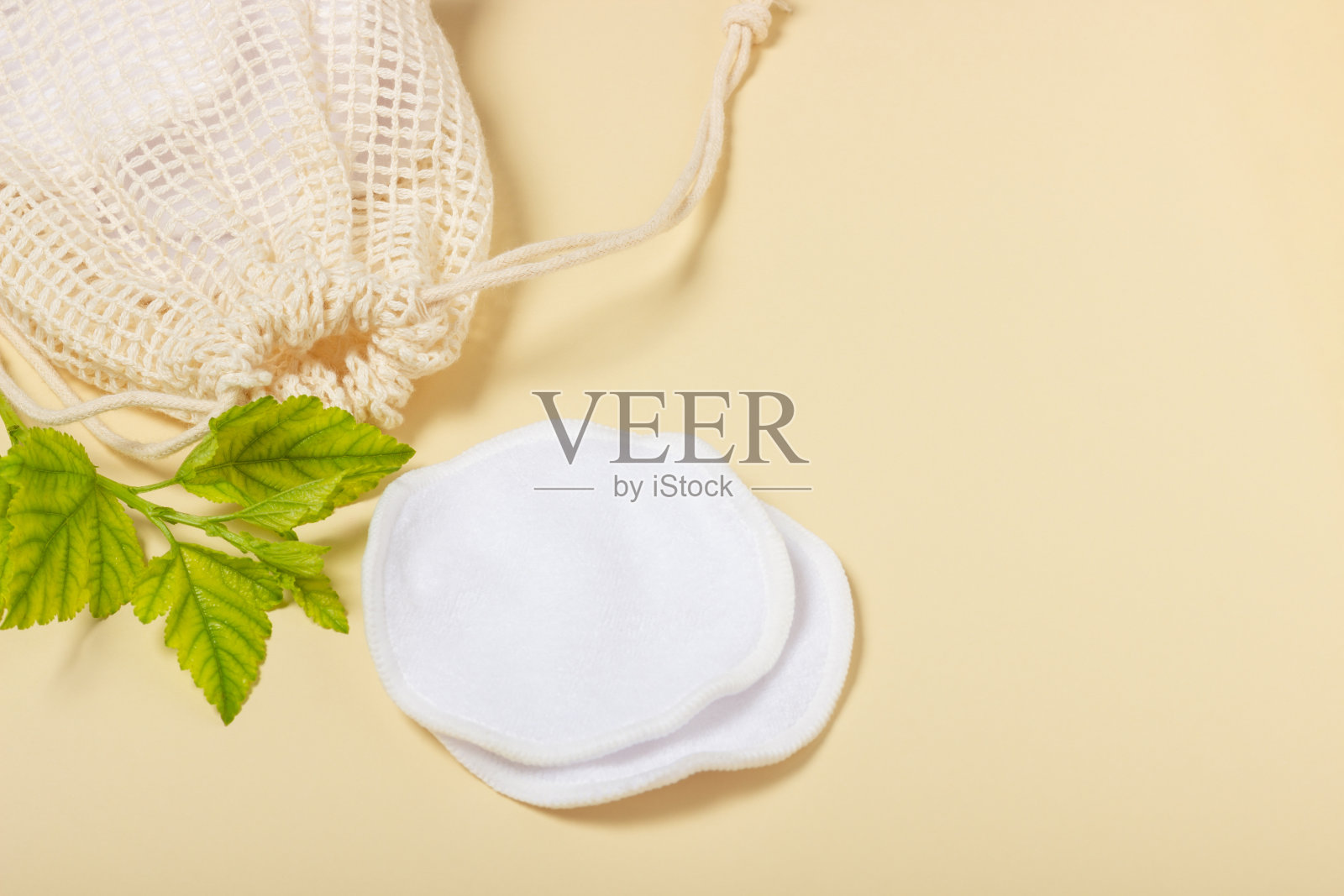 可重复使用的化妆卸妆棉垫在布袋在米色背景。生态观念与自觉消费。可重用的棉花垫照片摄影图片