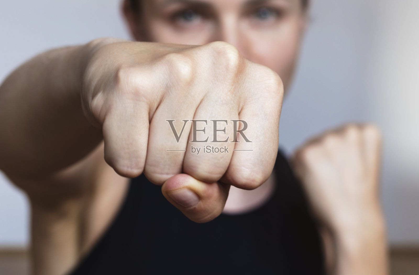 女运动员对着镜头出拳,重点是拳头。照片摄影图片