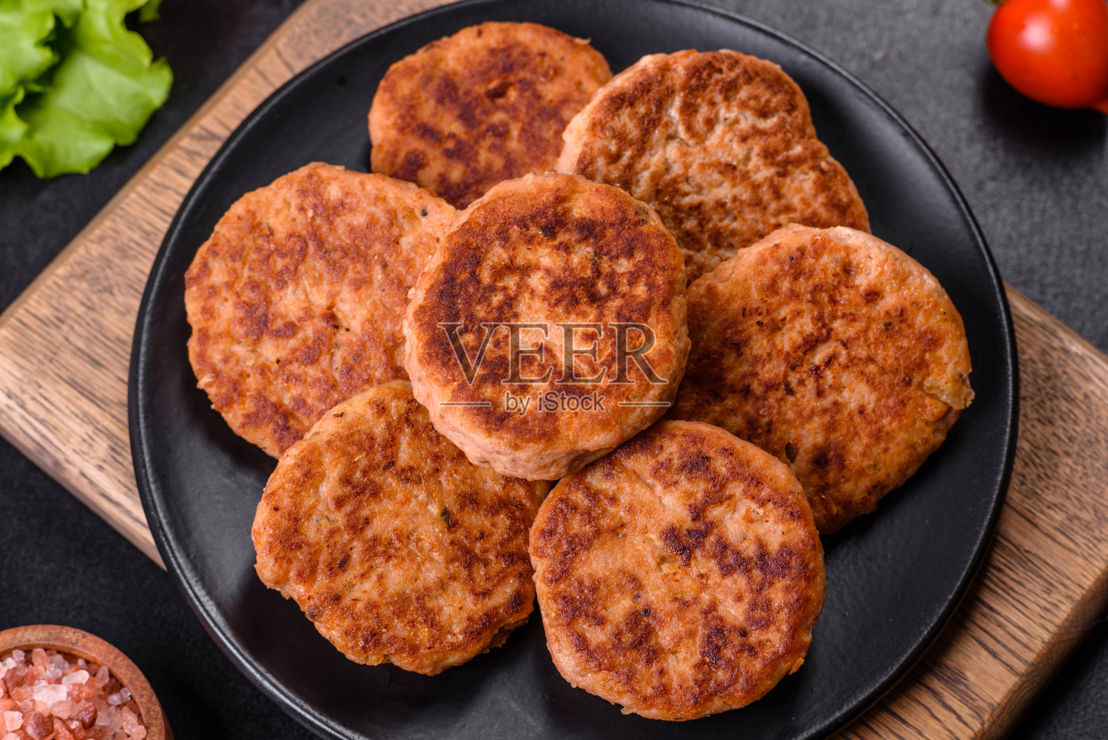 黑色盘子里是肉丸配番茄酱和香草照片摄影图片