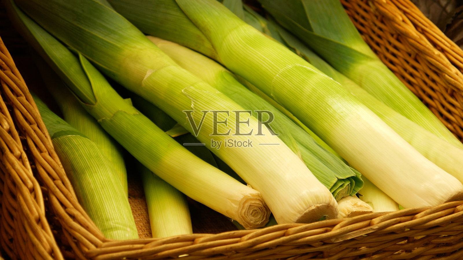 特写许多美丽的韭菜在柳条篮子照片摄影图片