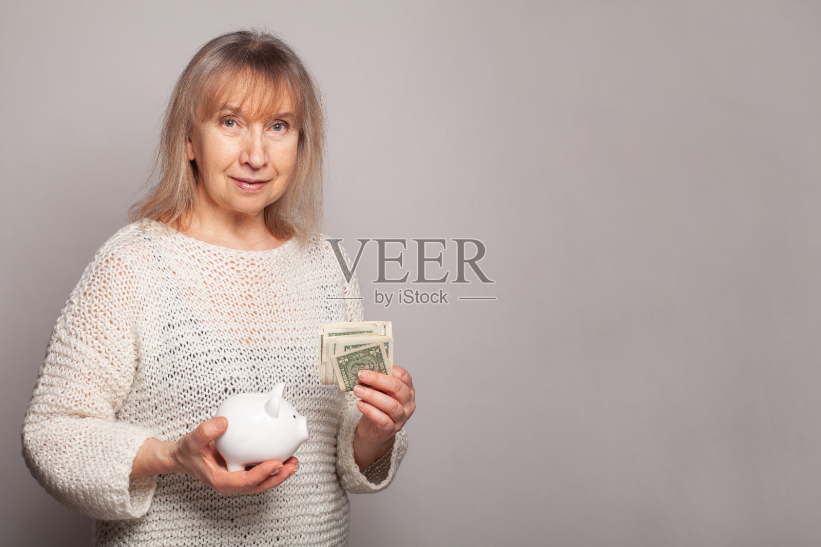 成熟的女人与美元和小猪银行对白色背景与拷贝空间照片摄影图片